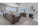 Bright living room with a fireplace, tile flooring, and a large window with views of the exterior at 9451 E Becker Ln # 1041, Scottsdale, AZ 85260