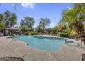 Community pool featuring lush landscaping and ample lounging space under a clear blue sky at 10132 E Isleta Ave, Mesa, AZ 85209