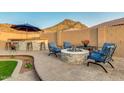 Outdoor kitchen and fire pit offers an ideal space for entertaining, with lush landscaping at 10251 W Gambit Trl, Peoria, AZ 85383