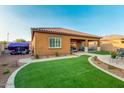 Beautiful backyard with artificial turf, a covered patio, and lovely landscaping at 10251 W Gambit Trl, Peoria, AZ 85383