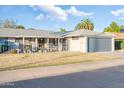 Charming home featuring a low-maintenance front yard, covered porch, and attached garage for convenient parking at 10326 W Kingswood Cir, Sun City, AZ 85351