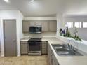 Well-lit kitchen features stainless steel appliances, light countertops and modern neutral-tone cabinetry at 1137 W 21St Ave, Apache Junction, AZ 85120