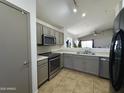 Bright kitchen with stainless appliances, tile floor and neutral cabinets flowing into the open concept living area at 1137 W 21St Ave, Apache Junction, AZ 85120
