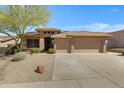 Charming single-story home with a three-car garage, a tile roof, and low-maintenance landscaping at 11413 S Coolwater Dr, Goodyear, AZ 85338