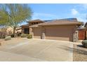 Inviting single-story home with a three-car garage, a tile roof, solar panels, and drought-tolerant landscaping at 11413 S Coolwater Dr, Goodyear, AZ 85338