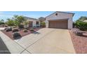 Charming single-story home with desert landscaping, solar panels, a long driveway and a two-car garage at 12950 W Quinto Dr, Sun City West, AZ 85375