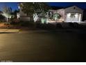 Charming single-story home with desert landscaping, a well-lit walkway, and a two-car garage at 12950 W Quinto Dr, Sun City West, AZ 85375