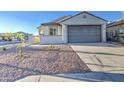 Well-maintained single-level home showcasing a spacious driveway and xeriscaped front yard at 20162 W Buchanan St, Buckeye, AZ 85326