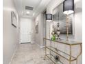 Elegant foyer with tray ceilings, a white front door, neutral wall colors and floors, and a console table at 22607 W Antelope Trl, Buckeye, AZ 85326