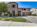 Charming two-story home featuring a stone facade and a well-manicured front yard with lush landscaping at 26722 N 90Th Ln, Peoria, AZ 85383