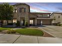 Charming two-story home featuring a stone facade and a well-manicured front yard with lush landscaping at 26722 N 90Th Ln, Peoria, AZ 85383