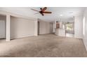 Open living room with neutral carpet and a ceiling fan at 38167 W Santa Clara Ave, Maricopa, AZ 85138