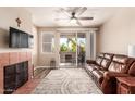 Inviting living room with balcony, fireplace, ceiling fan, and comfortable seating at 3830 E Lakewood E Pkwy # 2042, Phoenix, AZ 85048