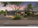 Charming single-story home with a manicured front yard, brick driveway, and cozy curb appeal at dusk at 3931 W Augusta Ave, Phoenix, AZ 85051