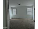 Spacious bedroom with neutral carpet, two windows, and ample natural light at 4330 N 94Th Ave, Phoenix, AZ 85037