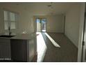 Sunlit living area showcases tile floors, white walls, and kitchen with stainless steel dishwasher and appliances at 4330 N 94Th Ave, Phoenix, AZ 85037