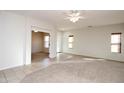 Expansive living room featuring neutral paint, carpet and tile flooring, and plenty of natural light at 44583 W Windrose Dr, Maricopa, AZ 85138