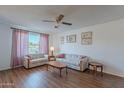 Cozy living room showcasing hardwood floors, two sofas, a ceiling fan, and natural light streaming through the window at 520 S Greenfield Rd # 22, Mesa, AZ 85206
