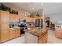 Spacious kitchen featuring light wood cabinets, stainless steel appliances, and a granite island at 5812 S Staghorn Cholla Ct, Gold Canyon, AZ 85118