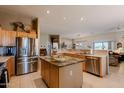 Open kitchen boasts stainless steel appliances, an island, and maple cabinets at 5812 S Staghorn Cholla Ct, Gold Canyon, AZ 85118