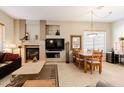 Cozy living room with a fireplace, comfortable seating, and an adjacent dining area for easy entertaining at 5812 S Staghorn Cholla Ct, Gold Canyon, AZ 85118