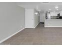 Open-concept living room with tile floors leading into the kitchen with white cabinets at 604 E Weber Dr # 12, Tempe, AZ 85288