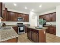 Kitchen boasts granite countertops, stainless appliances and dark wood cabinetry at 6204 S Banning St, Gilbert, AZ 85298