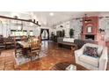 Spacious living area with tile floors, high ceilings, a brick fireplace, and an open kitchen at 9401 N 122Nd Pl, Scottsdale, AZ 85259