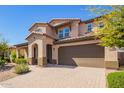 Inviting two-story home with a brick-paved driveway and a neatly landscaped front yard at 13660 N 144Th Ln, Surprise, AZ 85379