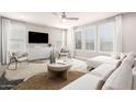 Bright living room with large windows, plush seating, modern decor, and ceiling fan at 13660 N 144Th Ln, Surprise, AZ 85379