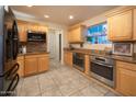 Bright kitchen features stainless steel appliances, granite counters, tile flooring, and custom wood cabinetry at 15021 N 19Th Way, Phoenix, AZ 85022