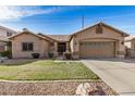 Well-maintained home features desert landscaping, a two-car garage, and a cozy front yard with green grass at 1569 E Princeton Ave, Gilbert, AZ 85234