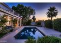 Inviting pool area with a sparkling pool, mature landscaping, and ample space for relaxation at dusk at 1614 E Kathleen Rd, Phoenix, AZ 85022