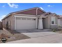 Single-story home featuring a two-car garage and xeriscaping at 17033 W Royal Palm Rd, Waddell, AZ 85355