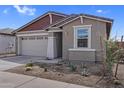 Single-story home featuring a two-car garage and xeriscaping at 17033 W Royal Palm Rd, Waddell, AZ 85355