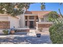 Inviting front entrance with a decorative door, stone accents, and well-maintained desert landscaping, enhancing curb appeal at 17246 N 56Th Way, Scottsdale, AZ 85254