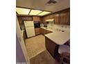 Cozy kitchen featuring wood cabinets, white appliances, and a breakfast bar at 17404 N 99Th Ave # 214, Sun City, AZ 85373