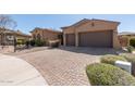 Inviting home featuring desert landscaping, a paved driveway and an attached two-car garage at 17953 W Willow Dr, Goodyear, AZ 85338