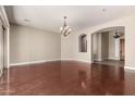 Spacious living room featuring hardwood floors, a stylish chandelier, and a seamless open floorplan at 17953 W Willow Dr, Goodyear, AZ 85338