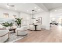 Open-concept living area with hardwood floors, neutral decor, and a dining area with modern lighting at 20453 N 95Th Pl, Scottsdale, AZ 85255