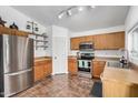 Cozy kitchen featuring tile flooring, stainless steel appliances, and wooden cabinets at 21941 W Solano Dr, Buckeye, AZ 85326