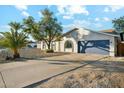 View of the home's exterior with a driveway, beautiful rock landscaping, and a blue two-car garage at 2253 S Emerson --, Mesa, AZ 85210