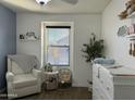 Bright Bedroom featuring a white glider, changing table, and stylish decor at 29031 N 125Th Ln, Peoria, AZ 85383