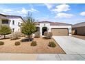 Charming single-story home with a well-maintained front yard, two car garage and terracotta colored roof tiles at 30382 W Vale Dr, Buckeye, AZ 85396