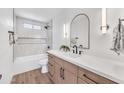 Modern bathroom showcasing a sleek vanity with a bright white countertop and updated tile in the shower at 3517 E Hartford Ave, Phoenix, AZ 85032