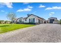 Stunning single Gathering home featuring a paver driveway leading to garages and a beautifully landscaped yard at 4037 E Minton Cir, Mesa, AZ 85215