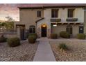 A cozy two-story home with a stone facade, wrought iron gate, and a well-maintained front yard at 470 N 168Th Ln, Goodyear, AZ 85338