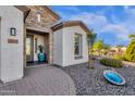 Inviting front entrance with stone accents, desert landscaping, and a blue decorative pot at 5100 S Peach Willow Ln, Gilbert, AZ 85298