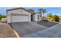 Beautiful single-story home featuring a well-manicured desert landscape and a brick-paved driveway at 5100 S Peach Willow Ln, Gilbert, AZ 85298