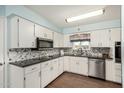 Bright kitchen with white cabinets, granite countertops, and stainless steel appliances at 5865 E Anaheim St, Mesa, AZ 85205